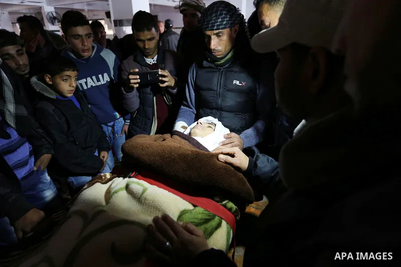 Palestinians mourn around the body of Palestinian Obeid Soufi, 25, who died after inhaling toxic gas inside the tunnel along the border between the Gaza Strip and Egypt during his funeral in Rafah in the southern Gaza st...