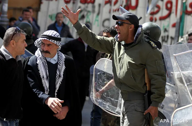 A Palestinian security officer reacts during clashes at a protest organised by Hizb-ut Tahrir against what organisers say are political arrests by the Palestinian Authority in the West Bank city of Hebron February 25, 20...