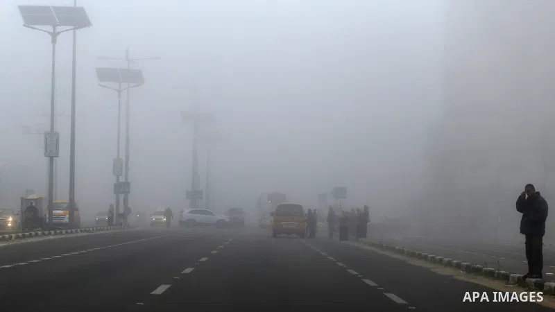 Palestinians walk at a street during foggy morning in Gaza city, on February 26, 2017. Photo by Yasser Qudih