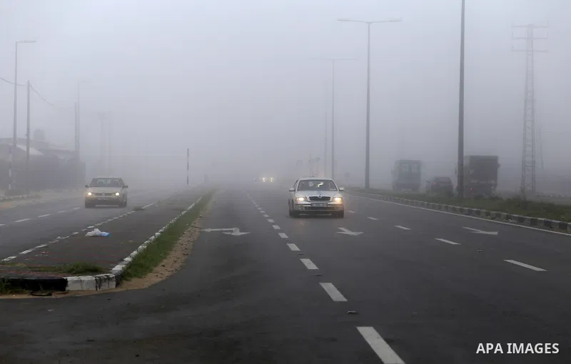 Palestinians ride cars at a street during foggy morning in Gaza city, on February 26, 2017. Photo by Yasser Qudih
