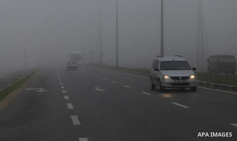 Palestinians ride cars at a street during foggy morning in Gaza city, on February 26, 2017. Photo by Yasser Qudih