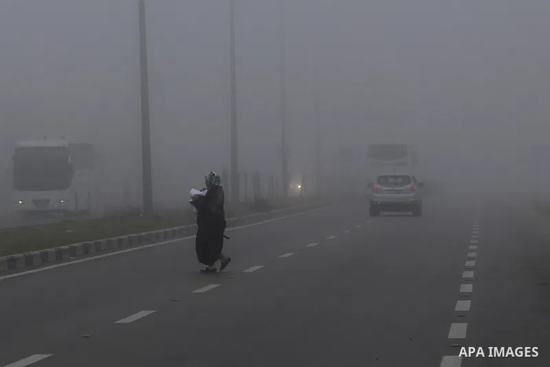 Palestinians walk at a street during foggy morning in Gaza city, on February 26, 2017. Photo by Yasser Qudih