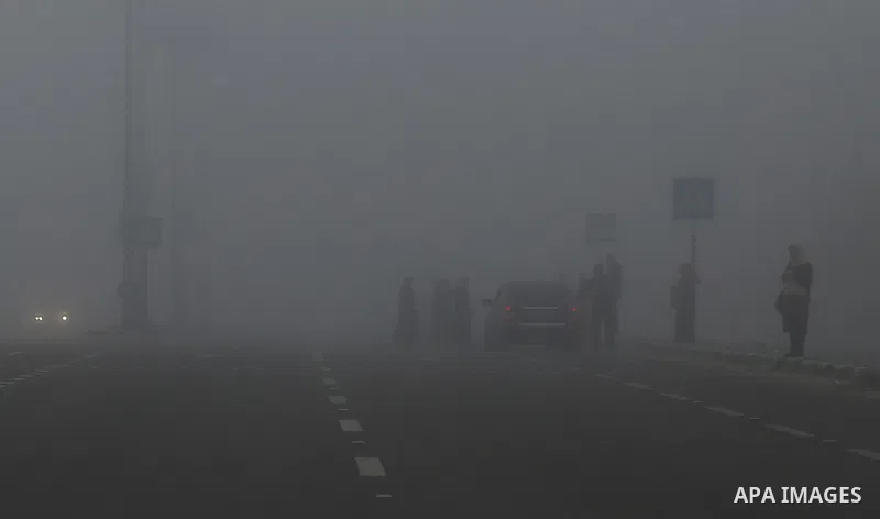 Palestinians walk at a street during foggy morning in Gaza city, on February 26, 2017. Photo by Yasser Qudih