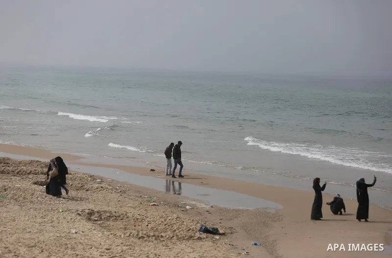 Palestinians stand in front of the beach at the Gaza seaport, during foggy morning, on February 26, 2017. Photo by Ashraf Amra