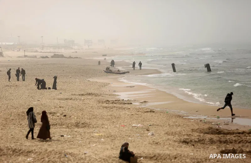 Palestinians stand in front of the beach at the Gaza seaport, during foggy morning, on February 26, 2017. Photo by Ashraf Amra