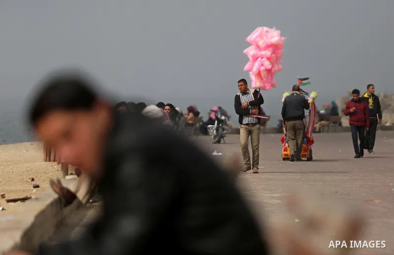 Palestinians stand in front of the beach at the Gaza seaport, during foggy morning, on February 26, 2017. Photo by Ashraf Amra
