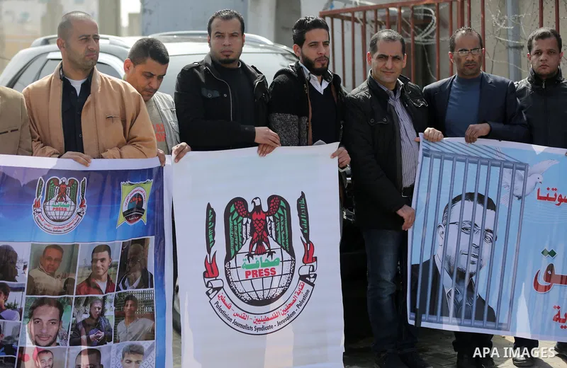 Palestinians hold placards during a protest to show solidarity with Palestinian prisoners held in Israeli Jails, in Gaza city, on February 26, 2017. Photo by Ashraf Amra