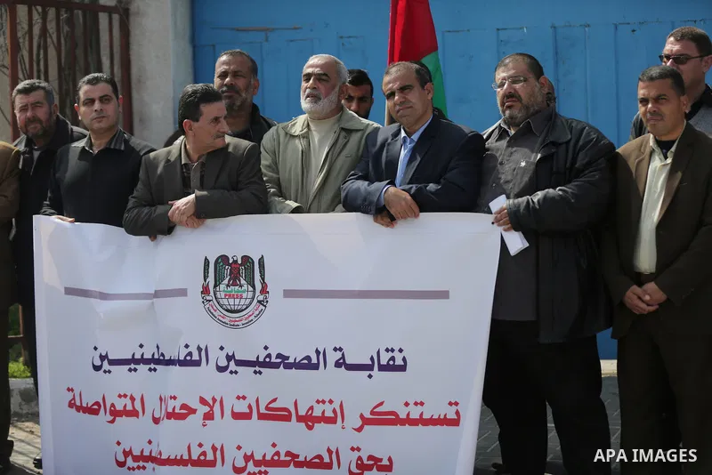 Palestinians hold placards during a protest to show solidarity with Palestinian prisoners held in Israeli Jails, in Gaza city, on February 26, 2017. Photo by Ashraf Amra