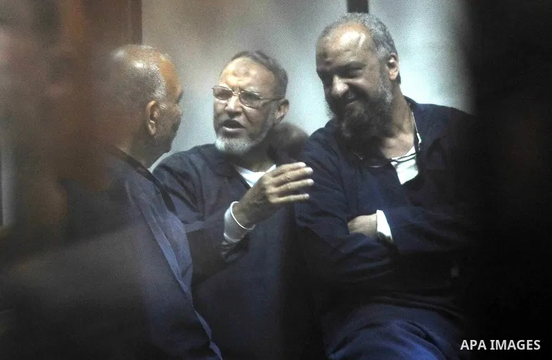 Defendants of Egyptian Muslim Brotherhood sit behind the defendants cage as they attend their trial along with Egyptian ousted president Mohammed Morsi (unseen), on the outskirts of the capital Cairo, on February 26, 201...
