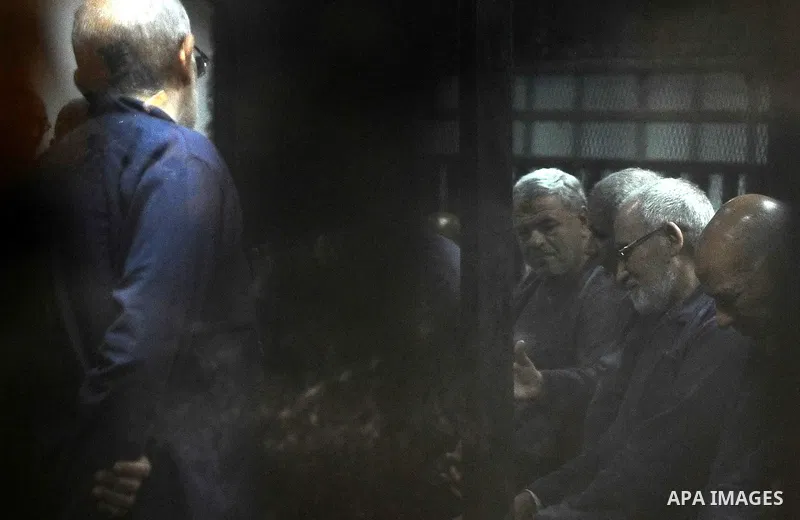 Defendants of Egyptian Muslim Brotherhood sit behind the defendants cage as they attend their trial along with Egyptian ousted president Mohammed Morsi (unseen), on the outskirts of the capital Cairo, on February 26, 201...