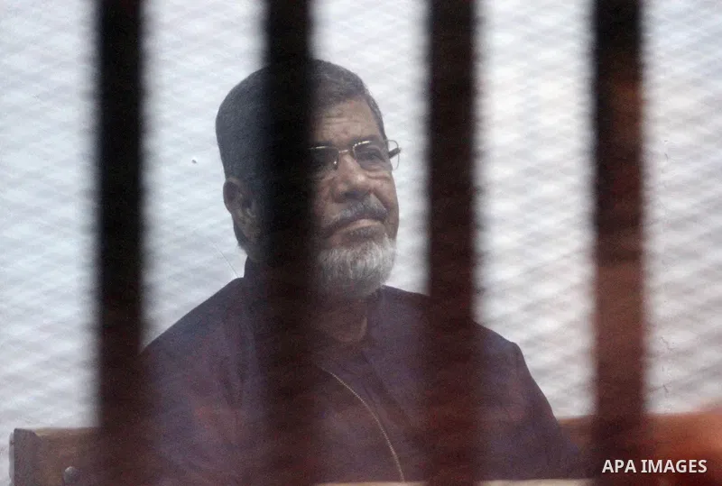 Egyptian ousted president Mohammed Morsi sits behind the defendants cage as he attends his trial at the police academy on the outskirts of the capital Cairo, on February 26, 2017. Photo by Stranger