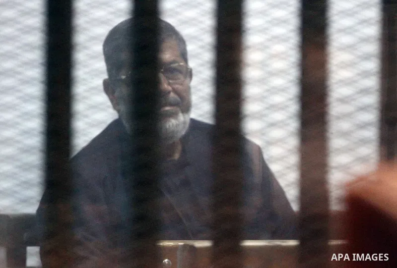 Egyptian ousted president Mohammed Morsi sits behind the defendants cage as he attends his trial at the police academy on the outskirts of the capital Cairo, on February 26, 2017. Photo by Stranger