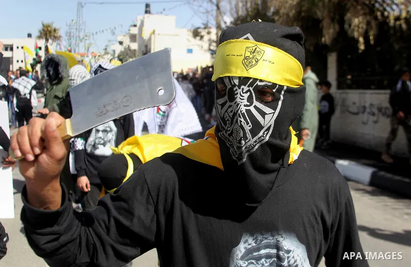 Masked Palestinians holds the pictures of Palestinian teenager Qusai Al-Amour, a 17-year-old who was shot dead, during a demonstration in the West Bank village of Tuqua, near Bethlehem, 26 February 2017. Emoor, a member...