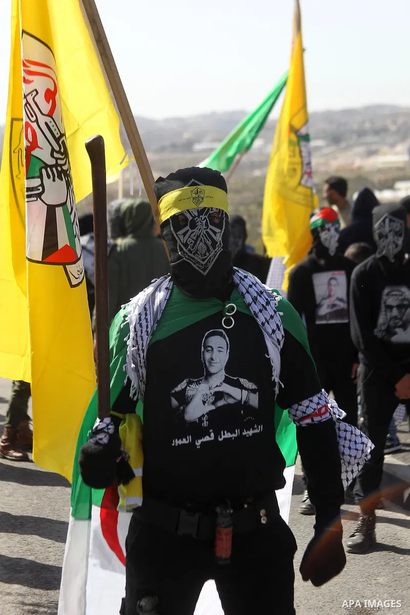 Masked Palestinians holds the pictures of Palestinian teenager Qusai Al-Amour, a 17-year-old who was shot dead, during a demonstration in the West Bank village of Tuqua, near Bethlehem, 26 February 2017. Emoor, a member...