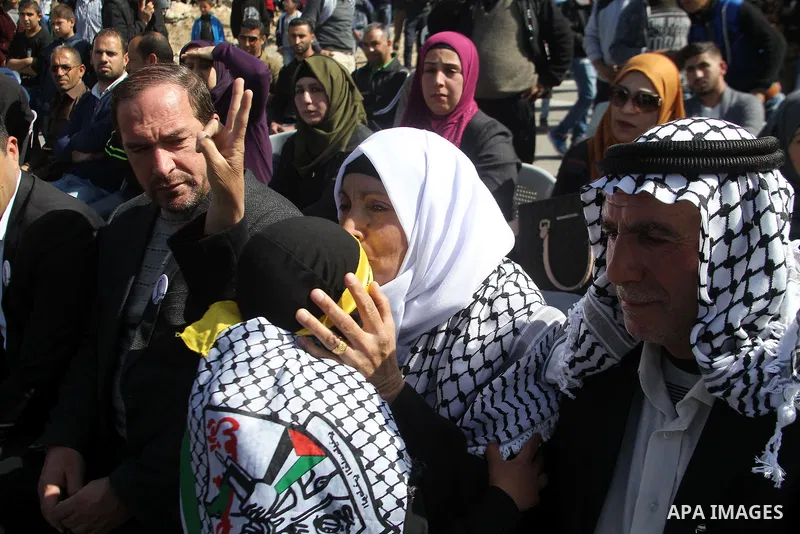 Masked Palestinians holds the pictures of Palestinian teenager Qusai Al-Amour, a 17-year-old who was shot dead, during a demonstration in the West Bank village of Tuqua, near Bethlehem, 26 February 2017. Emoor, a member...