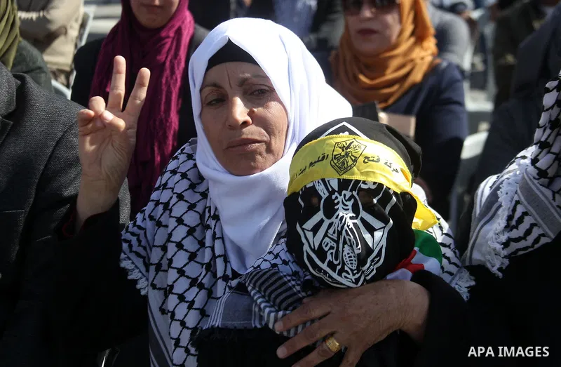 Masked Palestinians holds the pictures of Palestinian teenager Qusai Al-Amour, a 17-year-old who was shot dead, during a demonstration in the West Bank village of Tuqua, near Bethlehem, 26 February 2017. Emoor, a member...
