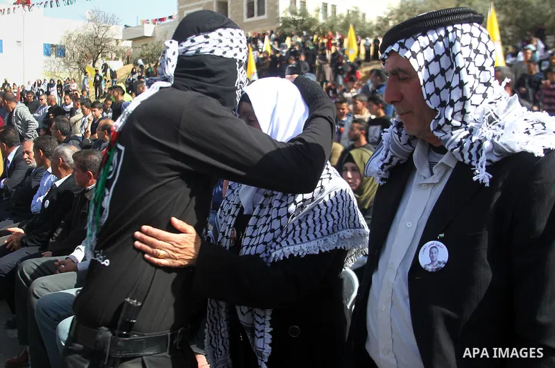 Masked Palestinians holds the pictures of Palestinian teenager Qusai Al-Amour, a 17-year-old who was shot dead, during a demonstration in the West Bank village of Tuqua, near Bethlehem, 26 February 2017. Emoor, a member...