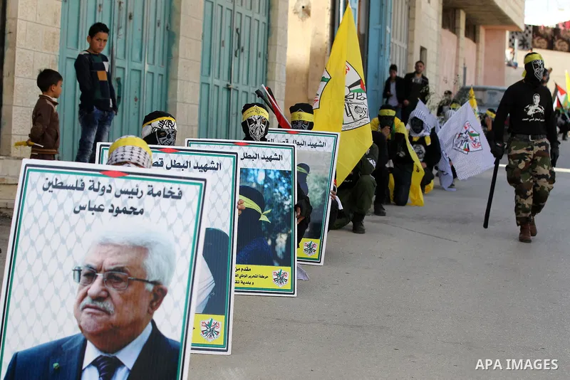 Masked Palestinians holds the pictures of Palestinian teenager Qusai Al-Amour, a 17-year-old who was shot dead, during a demonstration in the West Bank village of Tuqua, near Bethlehem, 26 February 2017. Emoor, a member...