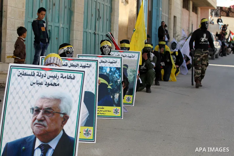 Masked Palestinians holds the pictures of Palestinian teenager Qusai Al-Amour, a 17-year-old who was shot dead, during a demonstration in the West Bank village of Tuqua, near Bethlehem, 26 February 2017. Emoor, a member...