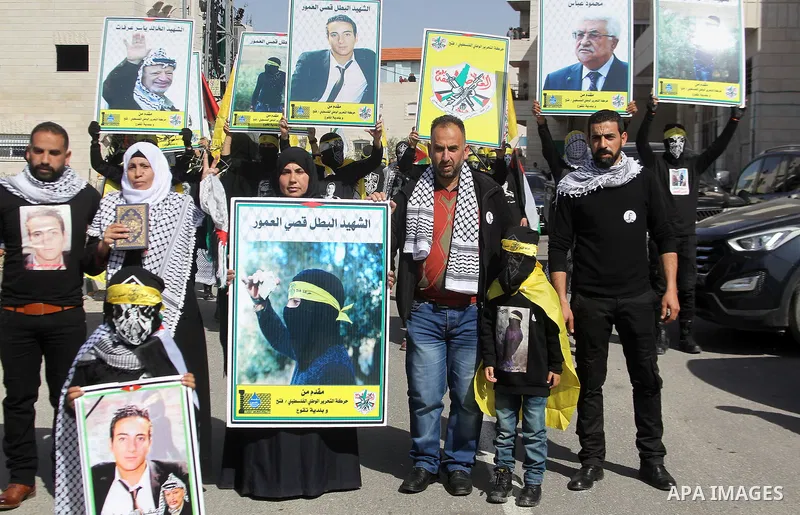 Masked Palestinians holds the pictures of Palestinian teenager Qusai Al-Amour, a 17-year-old who was shot dead, during a demonstration in the West Bank village of Tuqua, near Bethlehem, 26 February 2017. Emoor, a member...