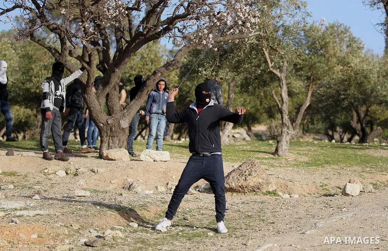A Palestinian protester uses a sling to hurl stones towards Israeli troops during clashes in the West Bank village of Tuqu near Bethlehem February 26, 2017. Photo by Wisam Hashlamoun