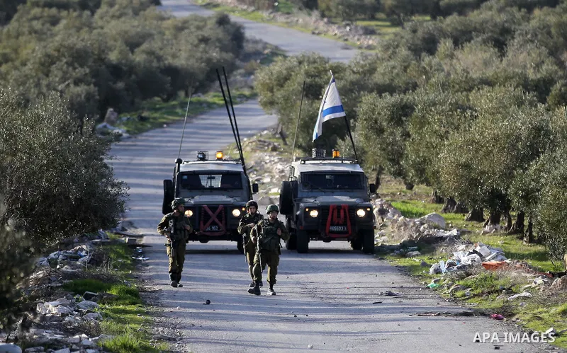 Israeli soldiers aim their weapons towards Palestinian protesters during clashes in the West Bank village of Tuqu near Bethlehem February 26, 2017. Photo by Wisam Hashlamoun