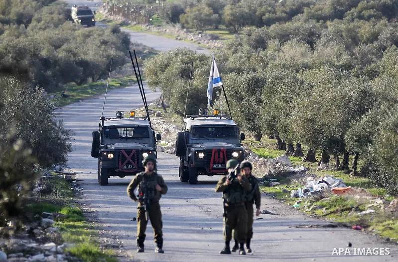 Israeli soldiers aim their weapons towards Palestinian protesters during clashes in the West Bank village of Tuqu near Bethlehem February 26, 2017. Photo by Wisam Hashlamoun