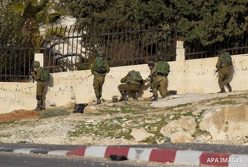 Israeli soldiers aim their weapons towards Palestinian protesters during clashes in the West Bank village of Tuqu near Bethlehem February 26, 2017. Photo by Wisam Hashlamoun