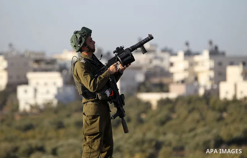 Israeli soldiers aim their weapons towards Palestinian protesters during clashes in the West Bank village of Tuqu near Bethlehem February 26, 2017. Photo by Wisam Hashlamoun