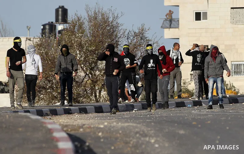 Palestinian protesters hurl stones towards Israeli troops during clashes in the West Bank village of Tuqu near Bethlehem February 26, 2017. Photo by Wisam Hashlamoun