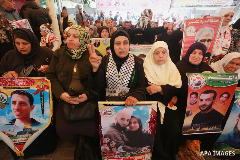 Palestinians hold placards during a protest to show solidarity with Palestinian prisoners held in Israeli Jails, in front of Red cross office in Gaza city, on February 27, 2017. Photo by Mohammed Asad