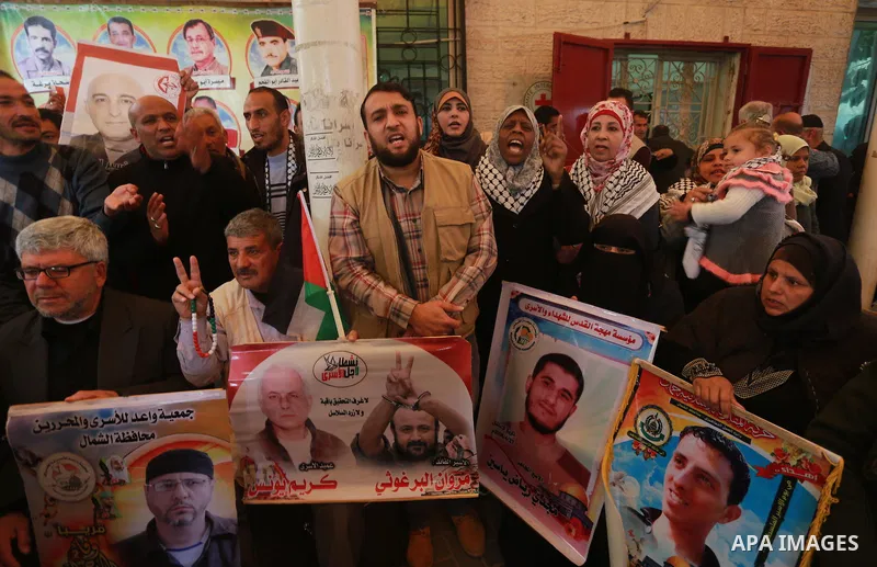 Palestinians hold placards during a protest to show solidarity with Palestinian prisoners held in Israeli Jails, in front of Red cross office in Gaza city, on February 27, 2017. Photo by Mohammed Asad