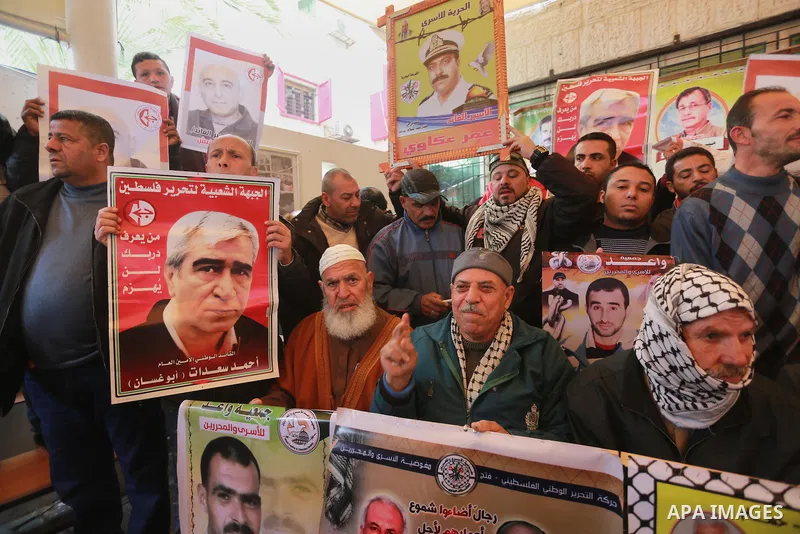 Palestinians hold placards during a protest to show solidarity with Palestinian prisoners held in Israeli Jails, in front of Red cross office in Gaza city, on February 27, 2017. Photo by Mohammed Asad