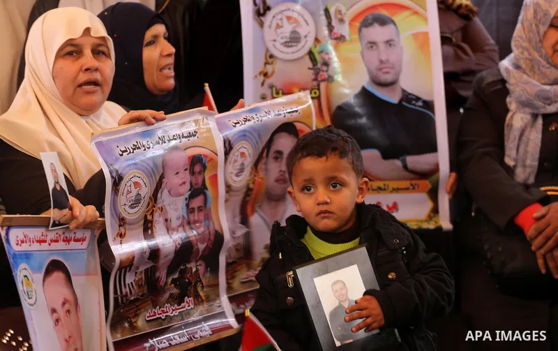 Palestinians hold placards during a protest to show solidarity with Palestinian prisoners held in Israeli Jails, in front of Red cross office in Gaza city, on February 27, 2017. Photo by Mohammed Asad