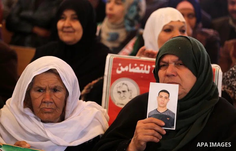 Palestinians hold placards during a protest to show solidarity with Palestinian prisoners held in Israeli Jails, in front of Red cross office in Gaza city, on February 27, 2017. Photo by Mohammed Asad