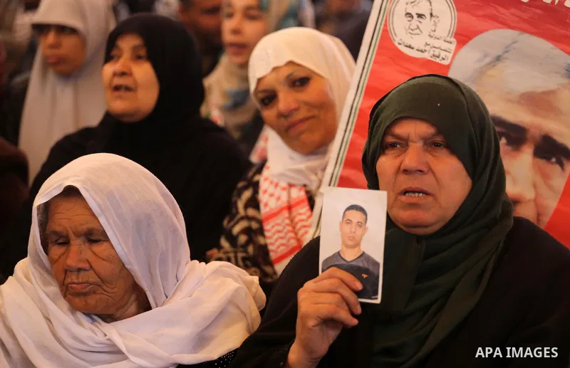 Palestinians hold placards during a protest to show solidarity with Palestinian prisoners held in Israeli Jails, in front of Red cross office in Gaza city, on February 27, 2017. Photo by Mohammed Asad