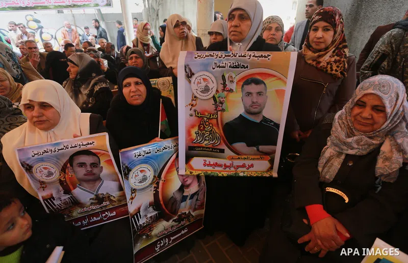 Palestinians hold placards during a protest to show solidarity with Palestinian prisoners held in Israeli Jails, in front of Red cross office in Gaza city, on February 27, 2017. Photo by Mohammed Asad