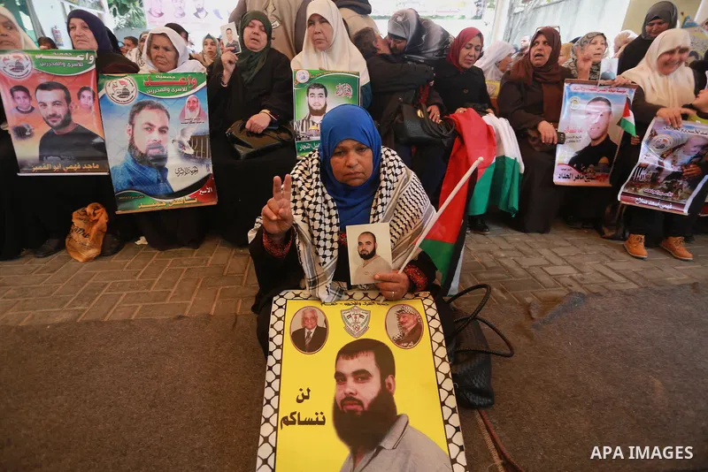 Palestinians hold placards during a protest to show solidarity with Palestinian prisoners held in Israeli Jails, in front of Red cross office in Gaza city, on February 27, 2017. Photo by Mohammed Asad