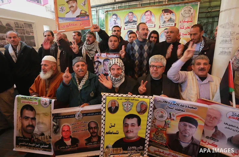 Palestinians hold placards during a protest to show solidarity with Palestinian prisoners held in Israeli Jails, in front of Red cross office in Gaza city, on February 27, 2017. Photo by Mohammed Asad