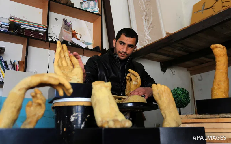 Palestinian artist, Mohammed Abu Hashish, 29, uses beeswax to produce models of human limb, at his workshop, in the al-Maghazi refugee camp, in the centre of the Gaza Strip, on February 27, 2017. Photo by Ashraf Amra