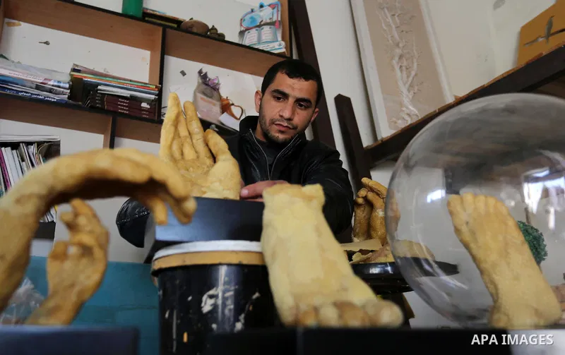 Palestinian artist, Mohammed Abu Hashish, 29, uses beeswax to produce models of human limb, at his workshop, in the al-Maghazi refugee camp, in the centre of the Gaza Strip, on February 27, 2017. Photo by Ashraf Amra