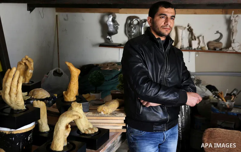 Palestinian artist, Mohammed Abu Hashish, 29, uses beeswax to produce models of human limb, at his workshop, in the al-Maghazi refugee camp, in the centre of the Gaza Strip, on February 27, 2017. Photo by Ashraf Amra
