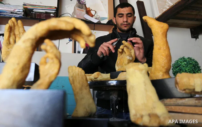 Palestinian artist, Mohammed Abu Hashish, 29, uses beeswax to produce models of human limb, at his workshop, in the al-Maghazi refugee camp, in the centre of the Gaza Strip, on February 27, 2017. Photo by Ashraf Amra