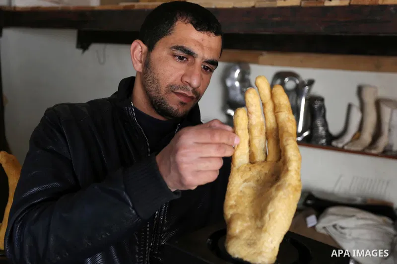 Palestinian artist, Mohammed Abu Hashish, 29, uses beeswax to produce models of human limb, at his workshop, in the al-Maghazi refugee camp, in the centre of the Gaza Strip, on February 27, 2017. Photo by Ashraf Amra