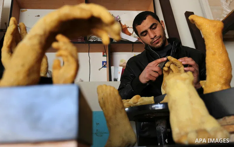 Palestinian artist, Mohammed Abu Hashish, 29, uses beeswax to produce models of human limb, at his workshop, in the al-Maghazi refugee camp, in the centre of the Gaza Strip, on February 27, 2017. Photo by Ashraf Amra