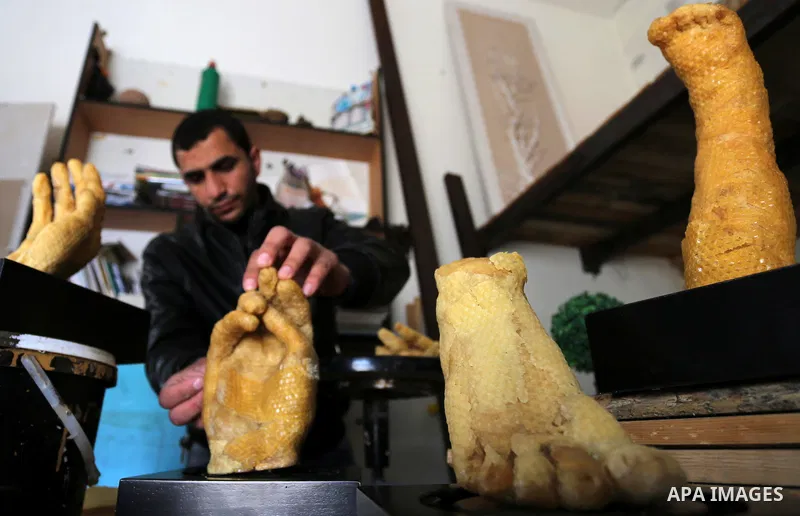 Palestinian artist, Mohammed Abu Hashish, 29, uses beeswax to produce models of human limb, at his workshop, in the al-Maghazi refugee camp, in the centre of the Gaza Strip, on February 27, 2017. Photo by Ashraf Amra