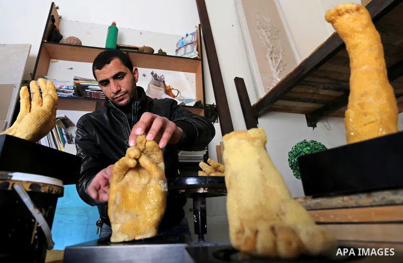 Palestinian artist, Mohammed Abu Hashish, 29, uses beeswax to produce models of human limb, at his workshop, in the al-Maghazi refugee camp, in the centre of the Gaza Strip, on February 27, 2017. Photo by Ashraf Amra