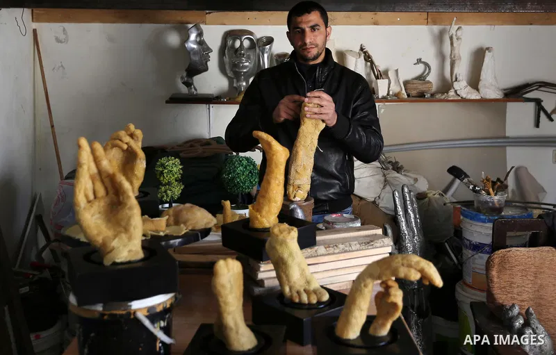 Palestinian artist, Mohammed Abu Hashish, 29, uses beeswax to produce models of human limb, at his workshop, in the al-Maghazi refugee camp, in the centre of the Gaza Strip, on February 27, 2017. Photo by Ashraf Amra