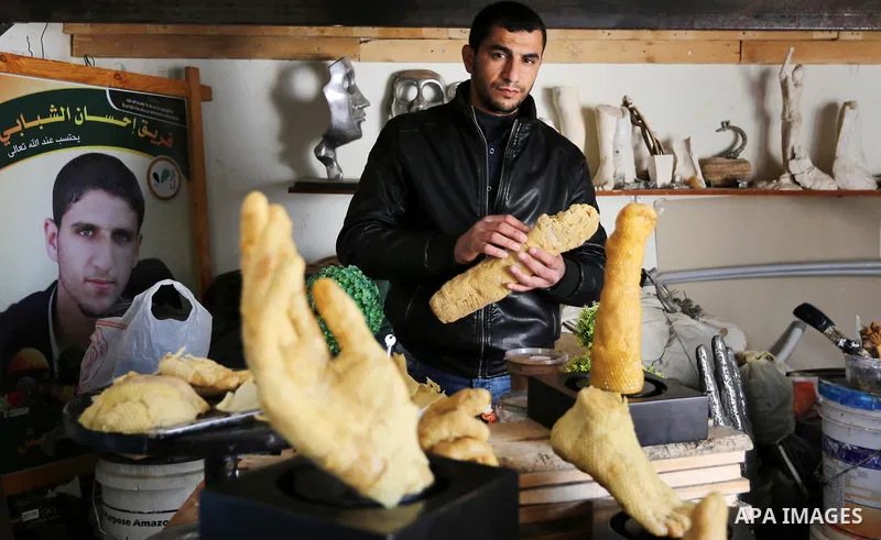 Palestinian artist, Mohammed Abu Hashish, 29, uses beeswax to produce models of human limb, at his workshop, in the al-Maghazi refugee camp, in the centre of the Gaza Strip, on February 27, 2017. Photo by Ashraf Amra