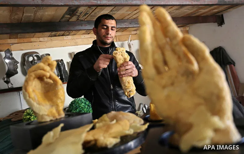 Palestinian artist, Mohammed Abu Hashish, 29, uses beeswax to produce models of human limb, at his workshop, in the al-Maghazi refugee camp, in the centre of the Gaza Strip, on February 27, 2017. Photo by Ashraf Amra